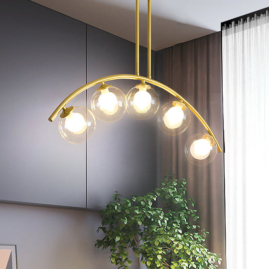 Modern Glass Orb Island Pendant Light With Brass Arch Arm - 5 Bulbs White/Clear Design For Dining