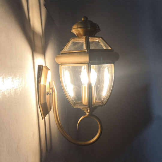 Brass Wall Sconce With Clear Glass Urn And Curved Arm Single Bulb Light Fixture