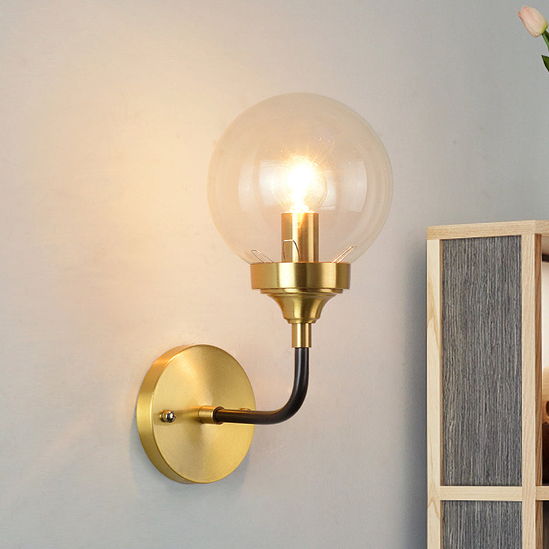 Clear Glass Globe Wall Sconce Light Fixture - Simple Brass With Curved Arm